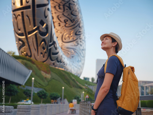 20 March 2023, Dubai, UAE: happy Tourist asian woman near Museum of The Future - New Attraction in Dubai downtown built for EXPO 2020