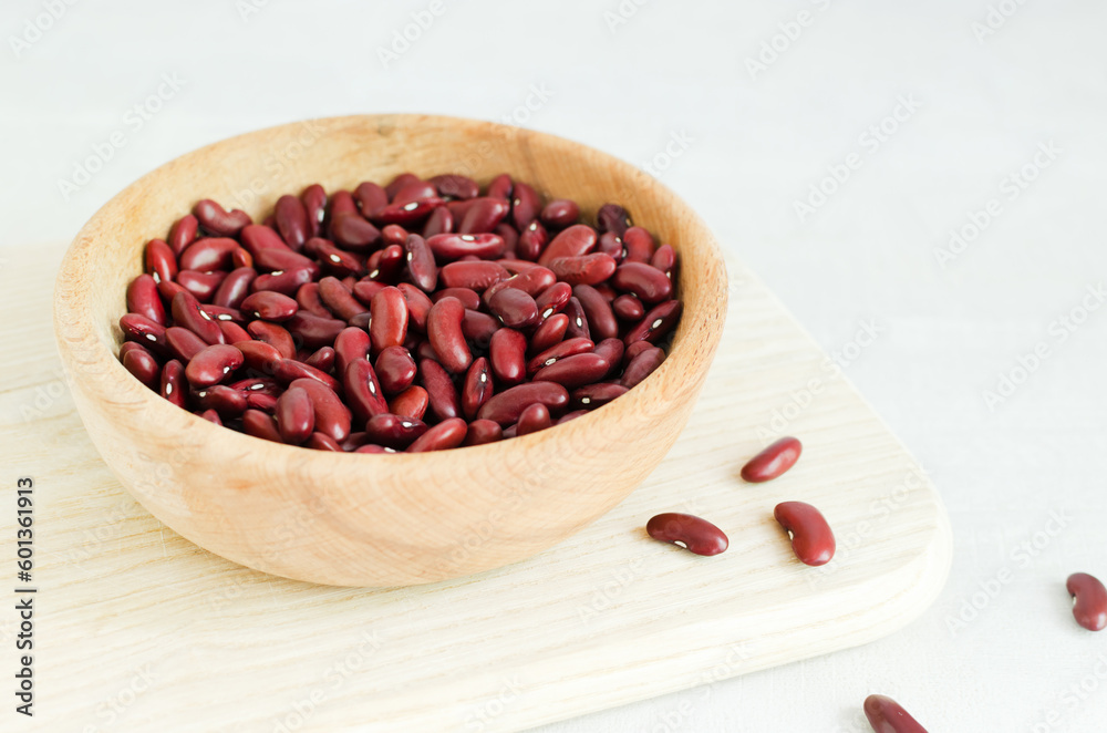 Raw red kidney beans in a wooden bowl. The concept of vegan food. The meal is enriched with protein. Ingredient for dietary dishes. Horizontal orientation. Selective focus. Copy space Raw red kidney beans in a wooden bowl. The concept of vegan food. The meal is enriched with protein. Ingredient for dietary dishes. Horizontal orientation. Selective focus. Copy space