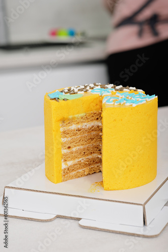 yellow layered cake with frosting. vertical shot of fresh baked and decorates bisquit cake.