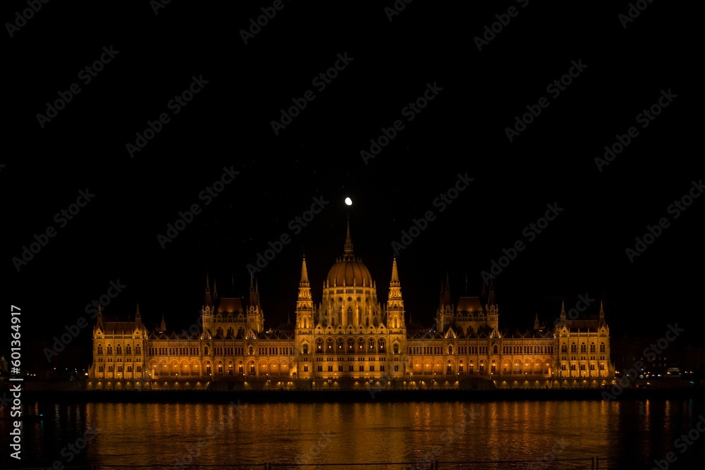 Parliament of Budapest at night with the moon above.