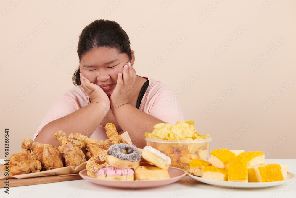 obesity young women binge eating disorder concept with woman eating fast food burger, fired chicken , donuts and desserts, junk food, high calorie foods, overweight female have unhealthy lifestyle. obesity young women binge eating disorder concept with woman eating fast food burger, fired chicken , donuts and desserts, junk food, high calorie foods, overweight female have unhealthy lifestyle.