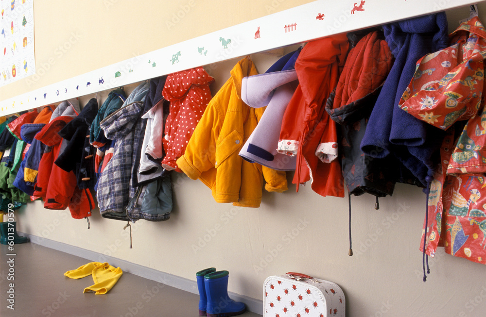 Coat rack in a nursery with a lot of children coats on a rack  - obrazy, fototapety, plakaty 