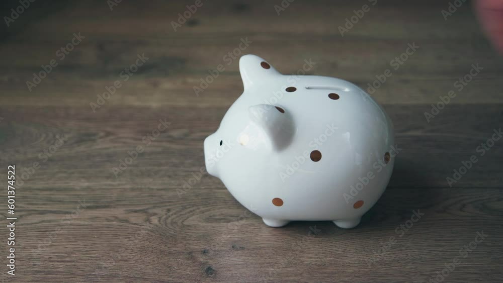 Saving money to piggy bank. Money saving concept. Hand puts the coins in the bank of money, savings. Saving money to piggy bank. Money saving concept. Hand puts the coins in the bank of money, savings.