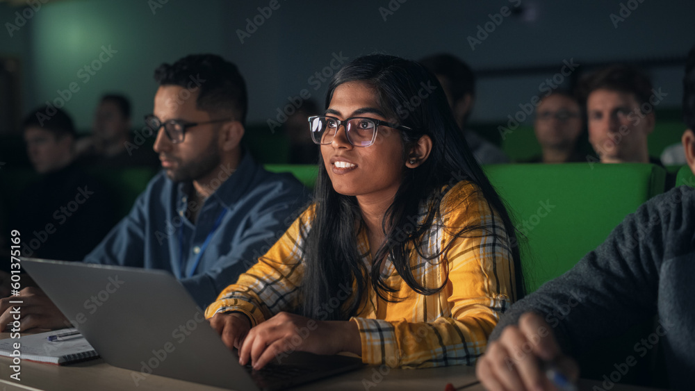 Portrait of a Smart Talented Indian Female Student Studying in University with Diverse Multiethnic Classmates. Young Woman Using Laptop Computer and Taking Notes During the Lecture - obrazy, fototapety, plakaty 