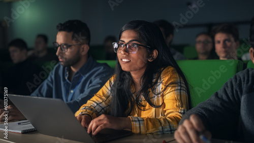 Portrait of a Smart Talented Indian Female Student Studying in University with Diverse Multiethnic Classmates. Young Woman Using Laptop Computer and Taking Notes During the Lecture