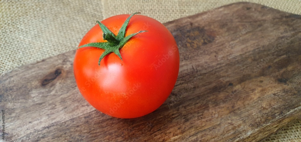 Ripe tomatoes on a wooden board close-up. Juicy tomatoes. Red tomatoes on the table. Fresh tomatoes for cooking.