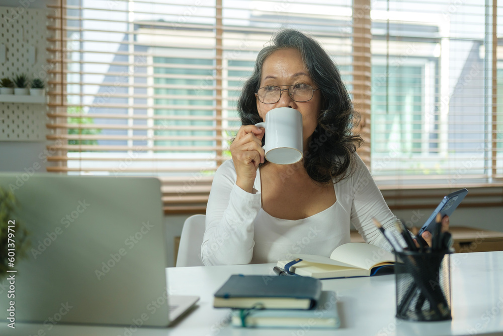 Portrait of calm senior woman drinking her morning coffee and looking out of the window. Portrait of calm senior woman drinking her morning coffee and looking out of the window.