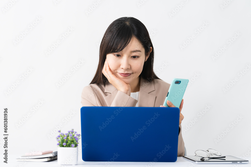 ノートパソコンとスマートフォンを使う若い女性 ビジネスイメージ ノートパソコンとスマートフォンを使う若い女性 ビジネスイメージ