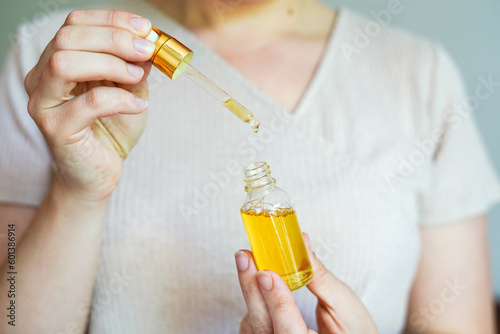 Woman holding glass bottle with spa cosmetic oil. salon therapy, natural eco body care products
