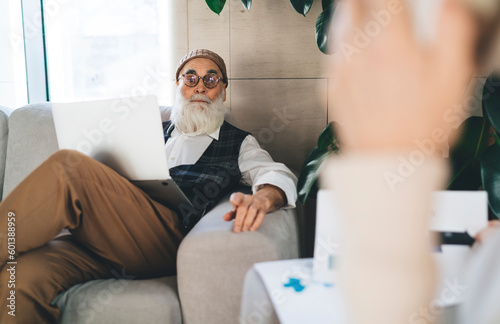 Elderly man with laptop working on project