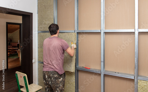 Workers insulate the wall in the room
