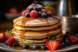 Stack of golden, fluffy pancakes topped with a generous drizzle of maple syrup, fresh berries, and a light dusting of powdered sugar.