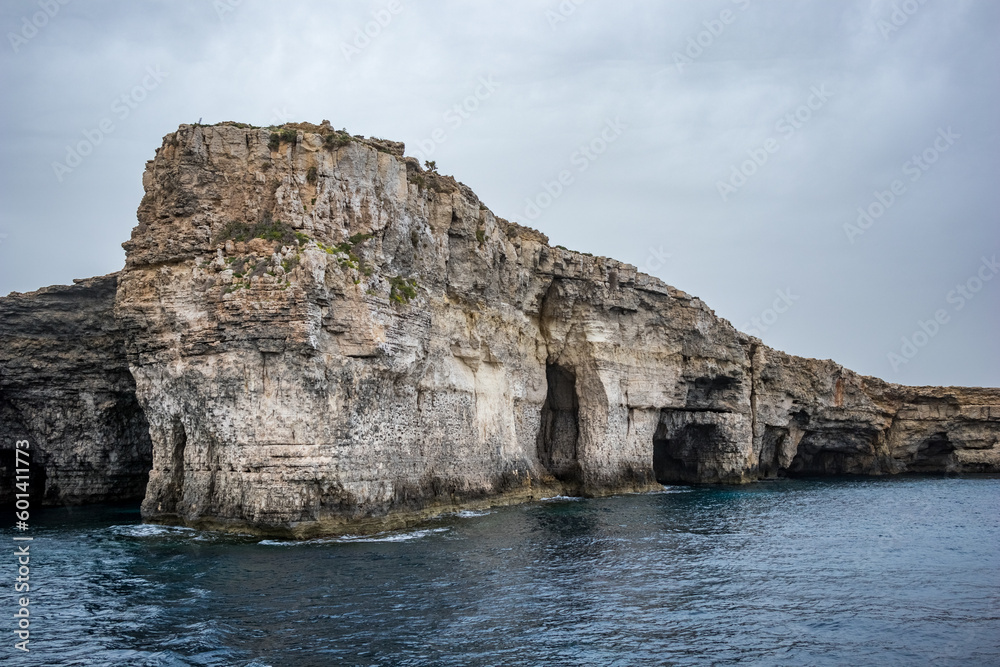 View from around Comino island, Malta. Scenery rocks in the sea. Moody spring time weather, cloudy day.
