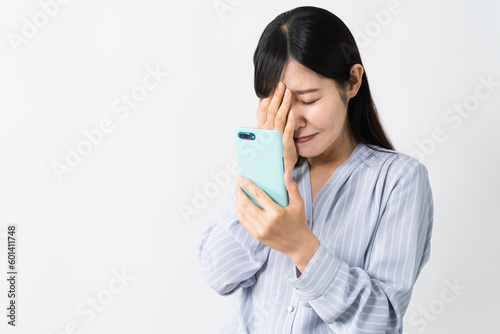 スマートフォンを持ちながら泣く若い女性