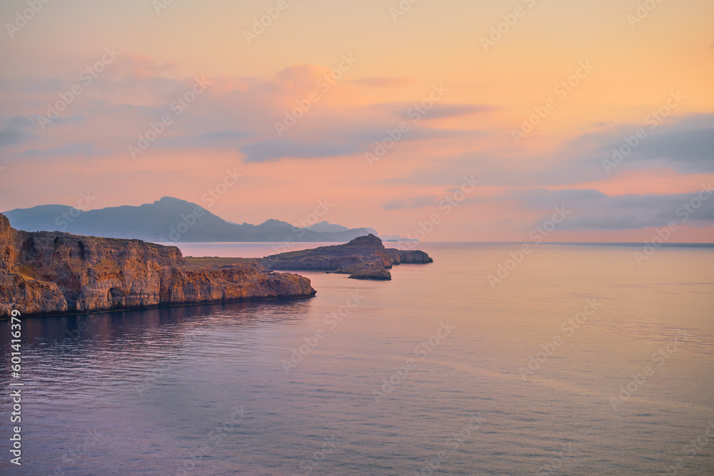 Magnificent scenery, views of the cliffs and the calm Mediterranean sea illuminated by the early morning sun, Rhodes is a famous destination for holidays and travel in the Greek islands Magnificent scenery, views of the cliffs and the calm Mediterranean sea illuminated by the early morning sun, Rhodes is a famous destination for holidays and travel in the Greek islands
