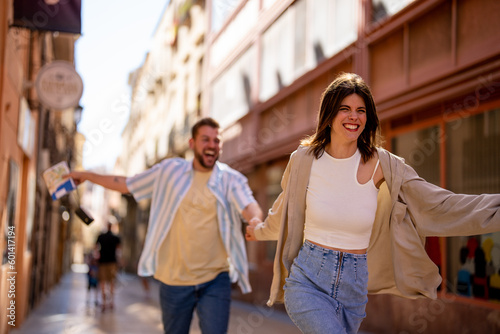 Playful couple having fun while running on the street.