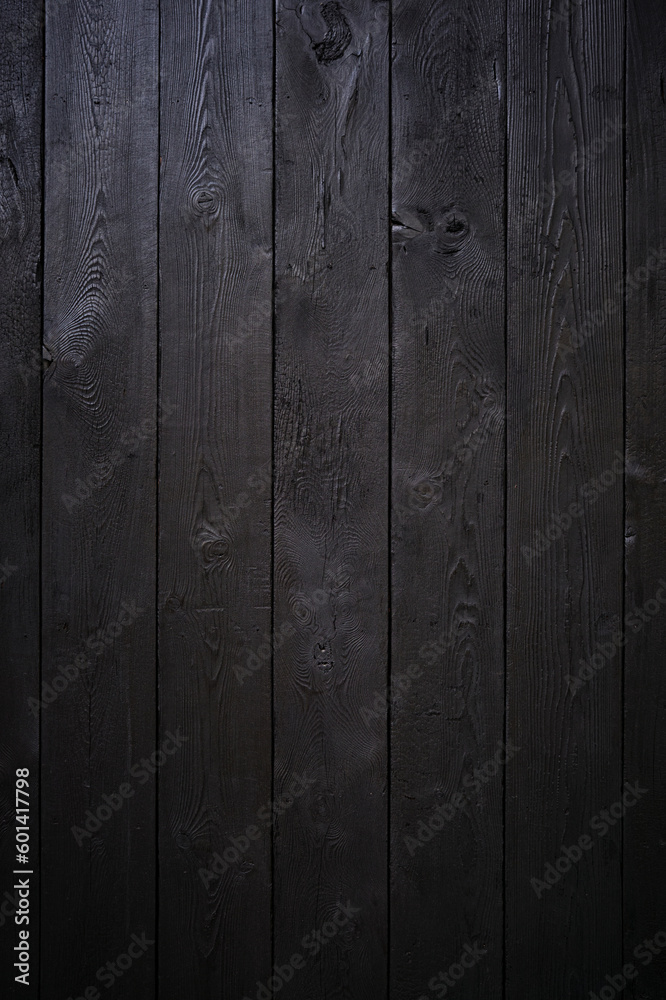 Vertical photo a beautiful wooden background made of boards painted black. Vertical photo a beautiful wooden background made of boards painted black.