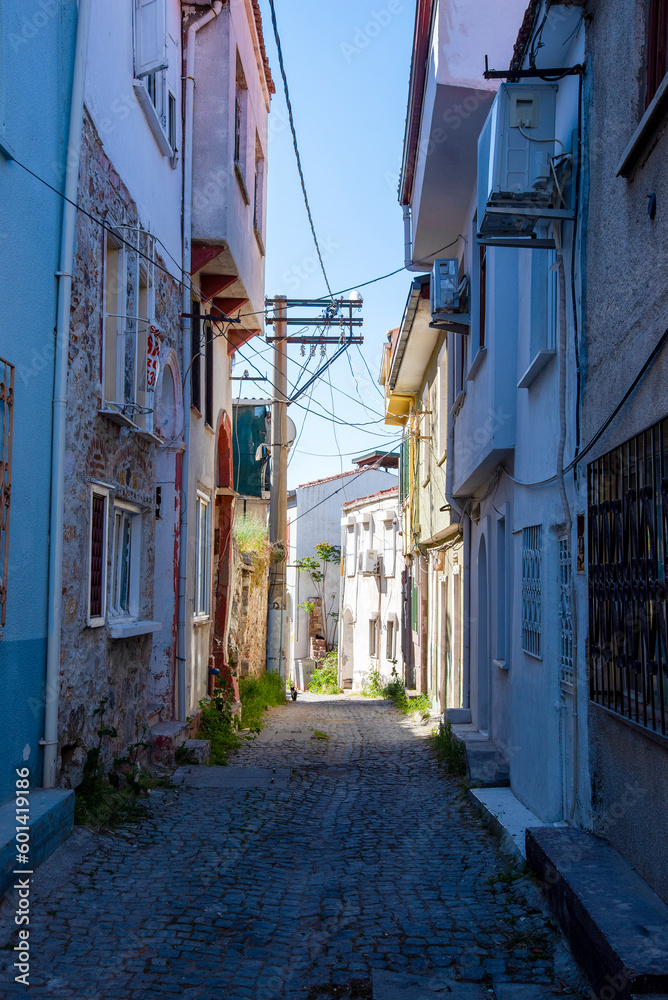 Narrow streets in a Turkish city on a summer and sunny day with old and masonry wooden houses.