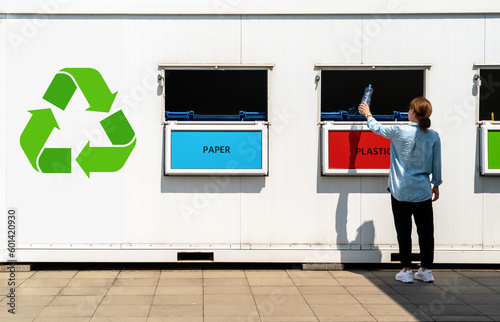 Fotografie Separate waste collection point on street and person throwing plastic trash in garbage bin