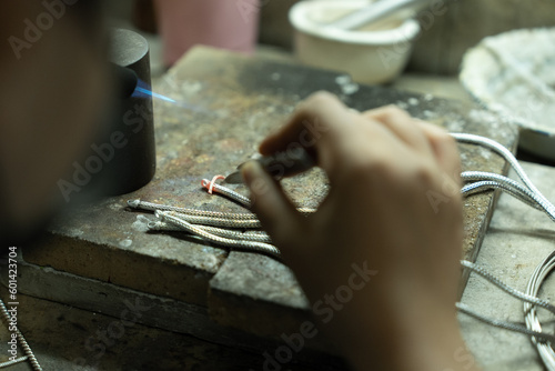 Jeweler at work in jewelry. Desktop for craft jewelry making with professional tools. Close up view of tools. Thailand.  © PIPAT