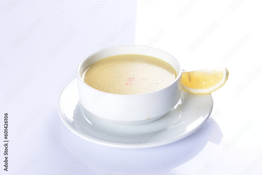 Lentil Soup with lemon and hot oil sauce, in white bowl Lentil Soup with lemon and hot oil sauce, in white bowl