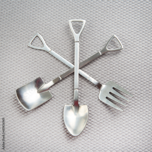 decorative fork and spoons in the form of spades on a gray background. food tools.