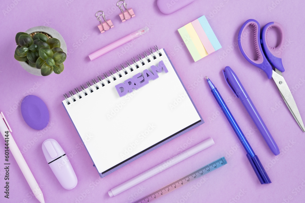 Empty notebook page for your text with violet and pink school and office stationery on violet background. Eraser in form of word dream. Flatly. Empty notebook page for your text with violet and pink school and office stationery on violet background. Eraser in form of word dream. Flatly.