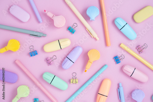 School pastel colors supplies. Stationery on pastel violet background. Highlighter in the form of shells. Flat lay.
