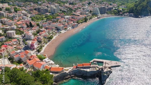 Aerial view - Petrovac city in Montenegro, summer sunny day. Sandy beach and mountains in shot photo