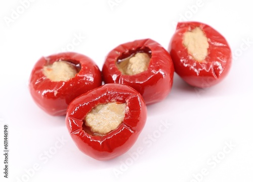 Red cherry peppers stuffed with tuna on white background.