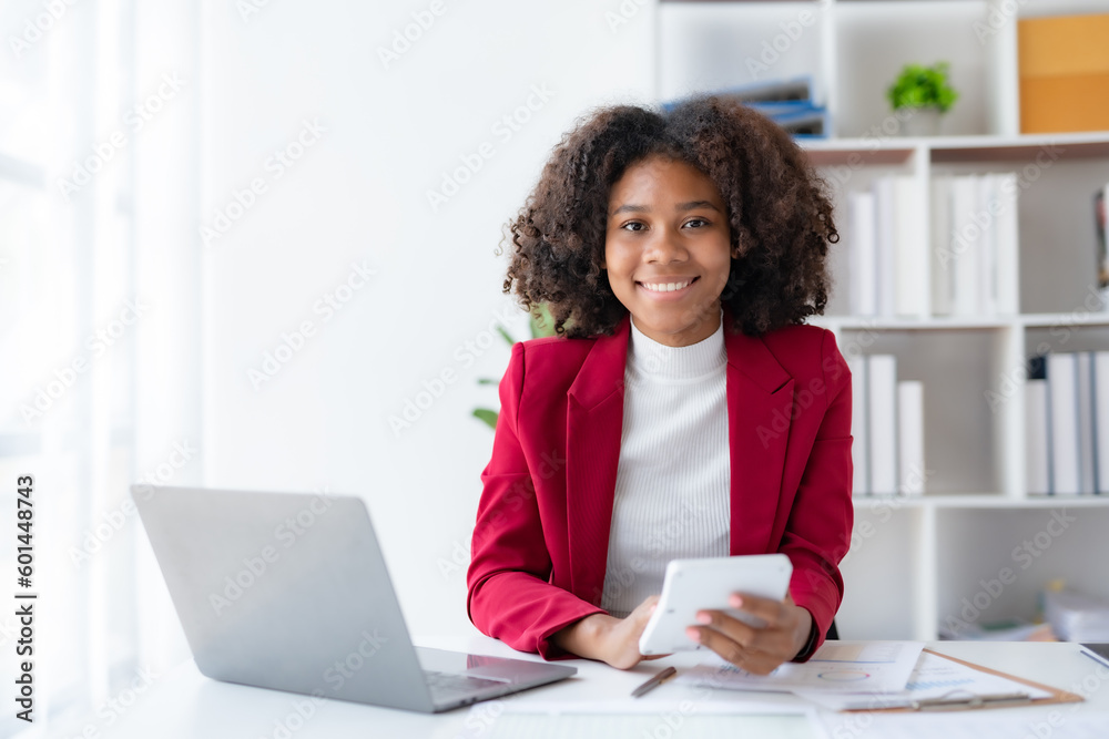 Happy Young African American businesswoman curly hair working with laptop computer in office. Happy Young African American businesswoman curly hair working with laptop computer in office.