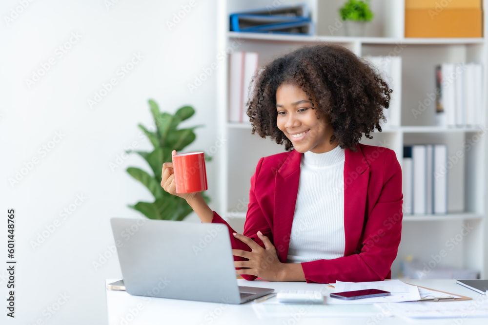 Happy businesswoman having video call on laptop computer and holding coffee at office. Happy businesswoman having video call on laptop computer and holding coffee at office.