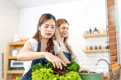 Young women preparing healthy food with salad vegetables. woman stsnding at pantry in a beautiful interior kitchen. The clean diet food from local products and ingredients Market fresh. photo