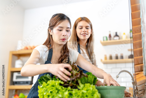 Young women preparing healthy food with salad vegetables. woman stsnding at pantry in a beautiful interior kitchen. The clean diet food from local products and ingredients Market fresh. photo