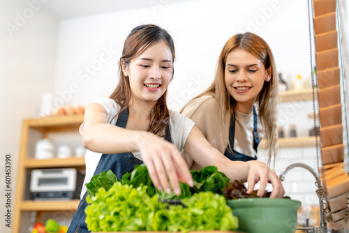 Young women preparing healthy food with salad vegetables. woman stsnding at pantry in a beautiful interior kitchen. The clean diet food from local products and ingredients Market fresh. photo