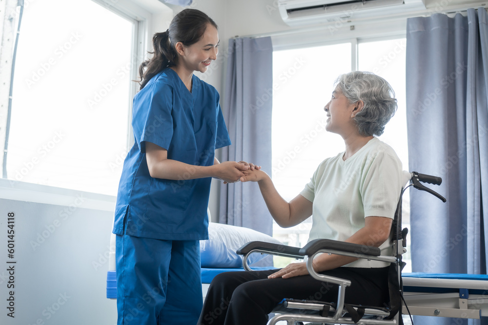 Fototapeta premium Asian senior care nurses and grandmothers provide caring support to elderly women hand clasp to encourage exercising with elder disabled person patient with caregiver in nursing care.