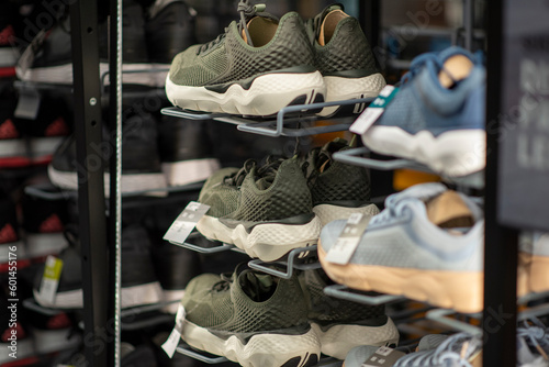Shop display of a lot of Sports shoes on a wall. A view of a wall of shoes inside the store. Modern new stylish sneakers running shoes for men and women - Dubai UAE December 2019. High quality photo