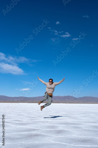 Woman jumping in the Salinas Grandes salt flat, Jujuy