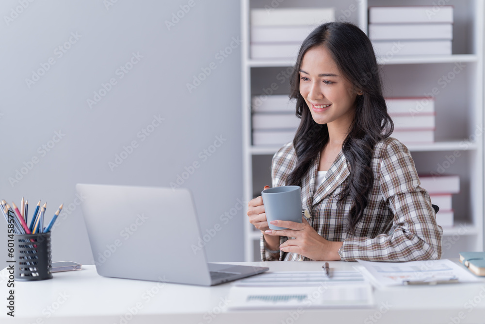 Young Asian businesswoman beautiful, charming smiling and using a laptop work in the office. Young Asian businesswoman beautiful, charming smiling and using a laptop work in the office.