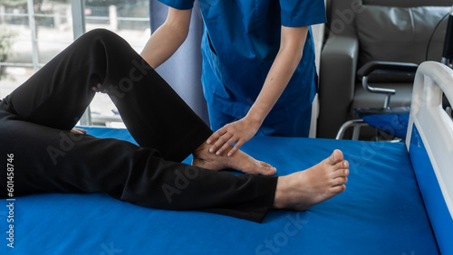 Asian female physiotherapist helping senior older woman stretching hamstring, Rehabilitation physiotherapy, elderly. Causes knee pain, swelling, redness, stiffness in knee, clunking noise in knee.