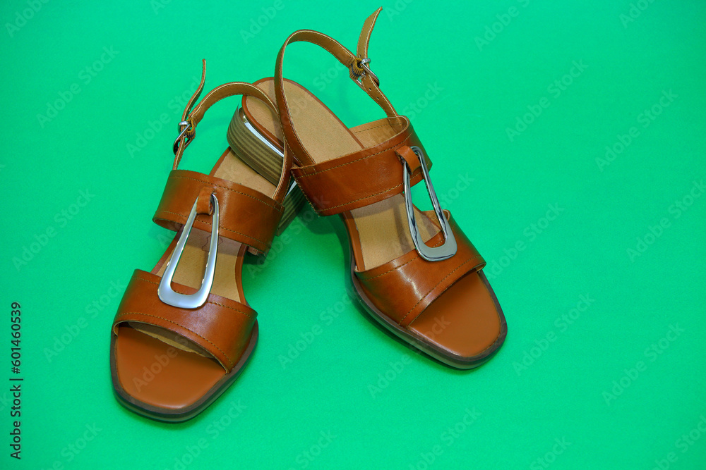Women's brown leather shoes. casual shoes, fashionable sports city walking shoes. close-up of the front and side. On a GREEN background.
