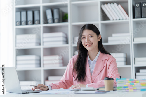 Shot of a beautiful young financial assistant sitting in front of laptop and fill the form in the office. © Tj