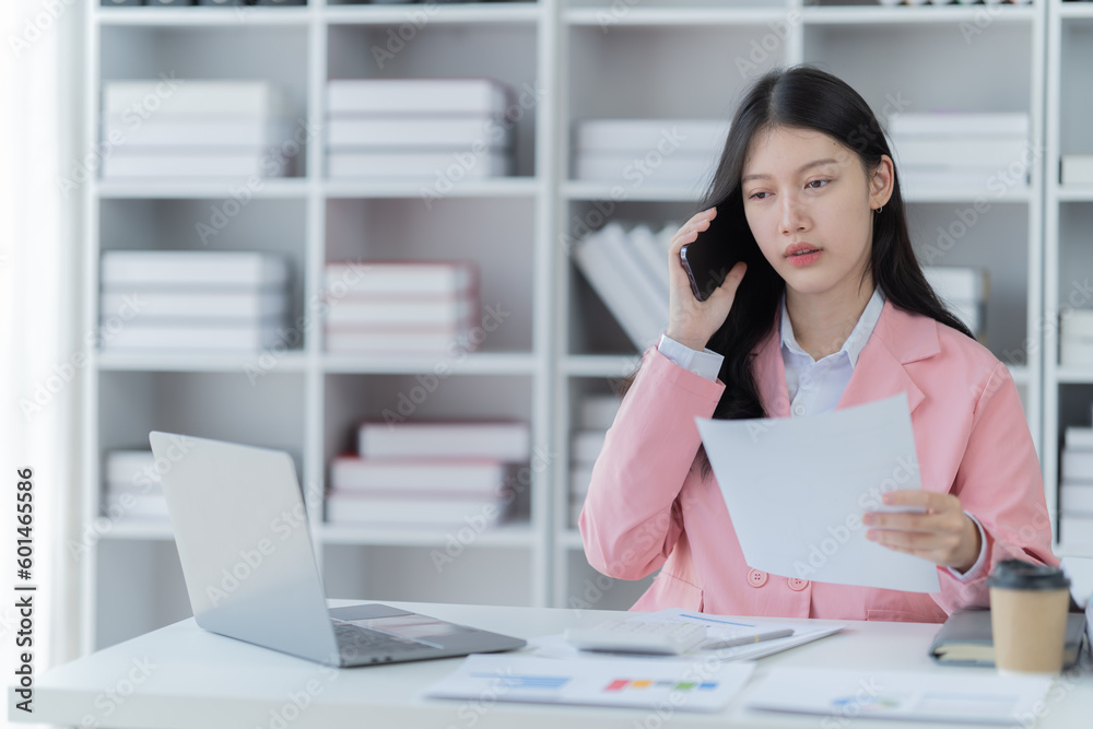 Shot of a beautiful young financial assistant sitting in front of laptop and fill the form in the office. Shot of a beautiful young financial assistant sitting in front of laptop and fill the form in the office.
