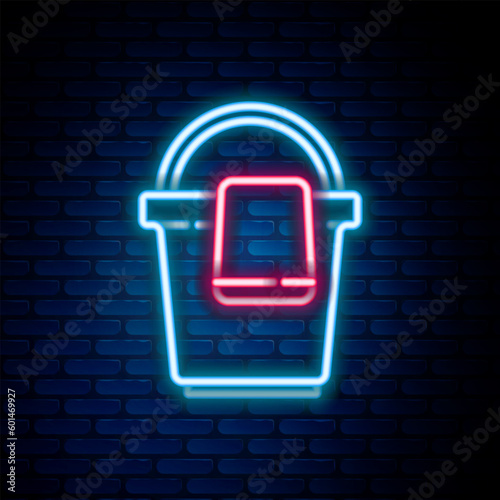 Glowing neon line Bucket with rag icon isolated on brick wall background. Cleaning service concept. Colorful outline concept. Vector