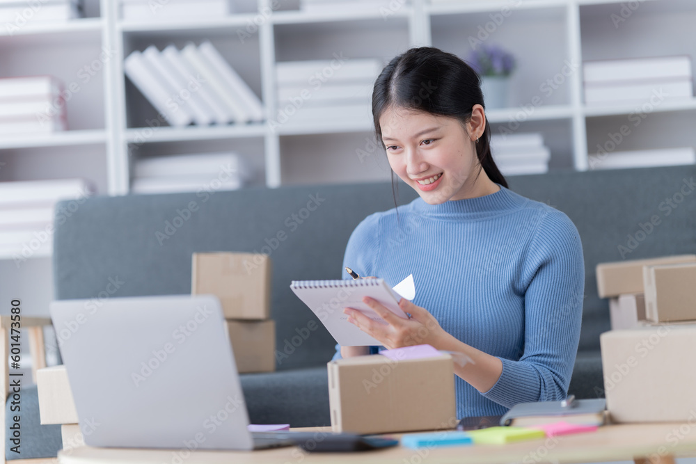 Startup SME small business entrepreneur of freelance Asian woman using a laptop with box Cheerful success Asian woman her hand lifts up online marketing packaging box and delivery SME Startup SME small business entrepreneur of freelance Asian woman using a laptop with box Cheerful success Asian woman her hand lifts up online marketing packaging box and delivery SME