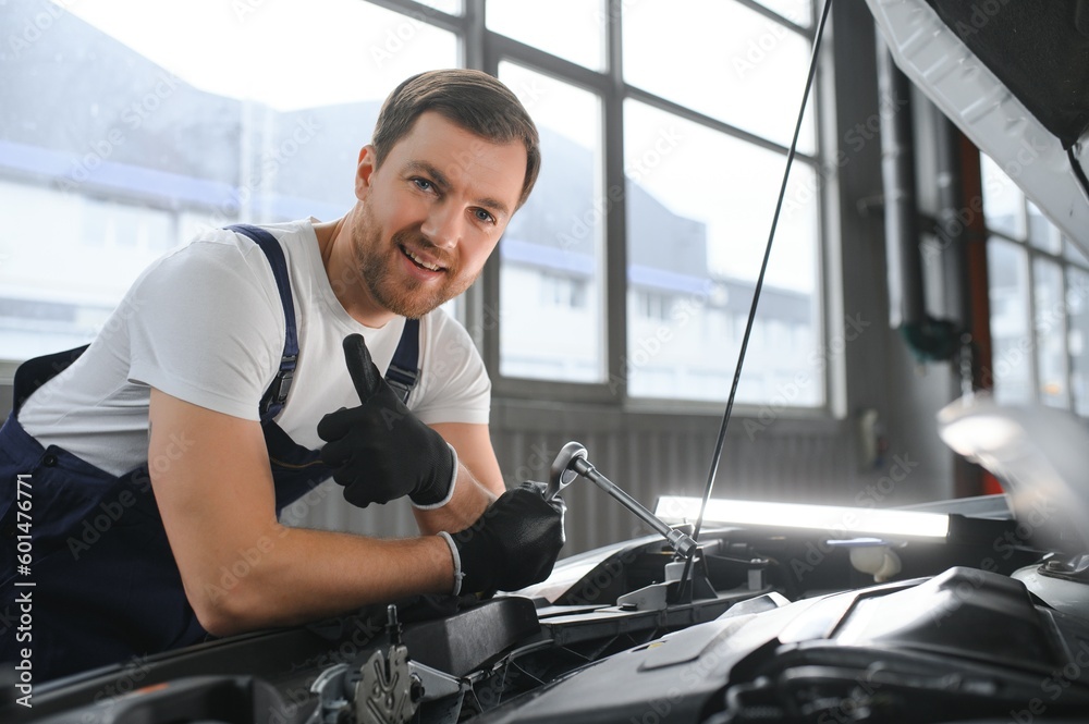 Portrait of a smiling fixing a car engine in his garage