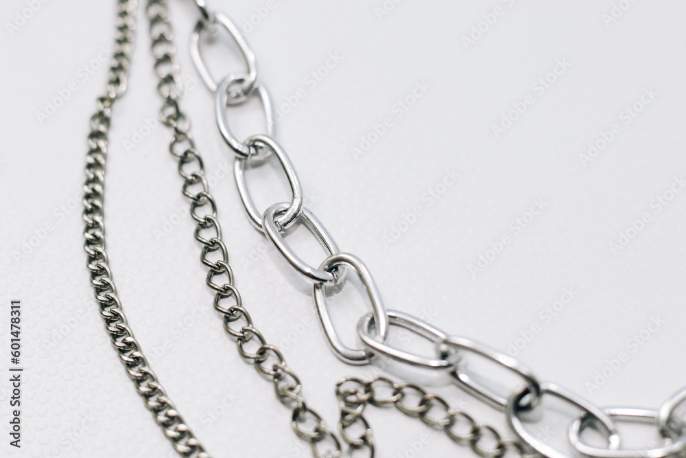 Different silver metal chains on a light background. Different silver metal chains on a light background.