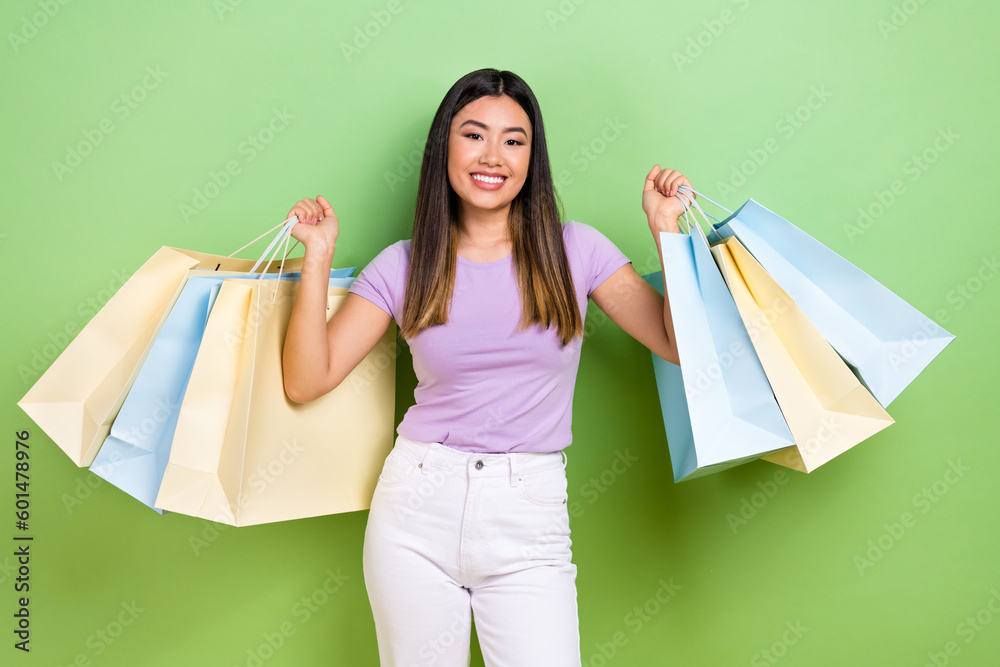 Photo of lovely japanese korean young lady hold shopping bags shopper wear trendy purple garment isolated on green color background Photo of lovely japanese korean young lady hold shopping bags shopper wear trendy purple garment isolated on green color background