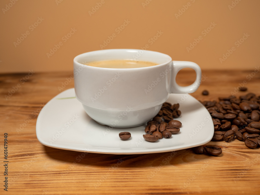 Cup of coffee and roasted coffee beans on a wooden background. Cup of coffee and roasted coffee beans on a wooden background.