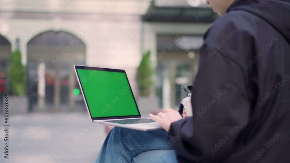 Young Girl Using Green Mock-up Screen Laptop on Street Young Girl Using Green Mock-up Screen Laptop on Street
